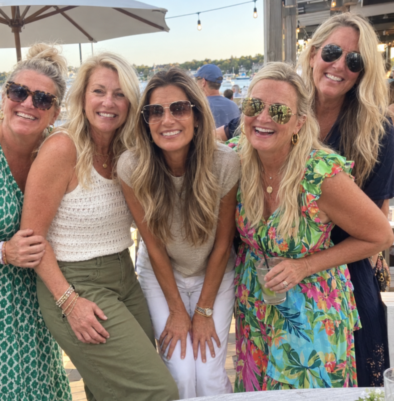 Susan and friends laughing at a waterfront bar