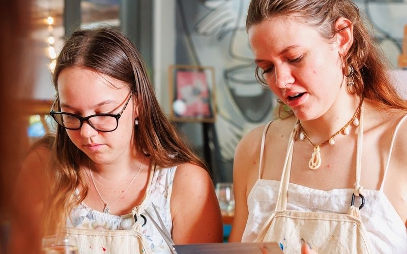 Friends together as they cut and glue their vision boards on a Sydney girls weekend