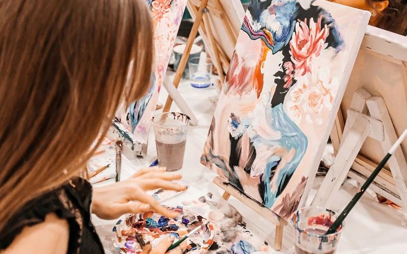 A friend adding colour to her canvas mid painting workshop on a Melbourne girls trip