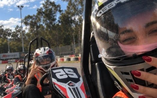 A helmeted selfie from the driver's seat on the karting grid, with the girls lined up in karts behind