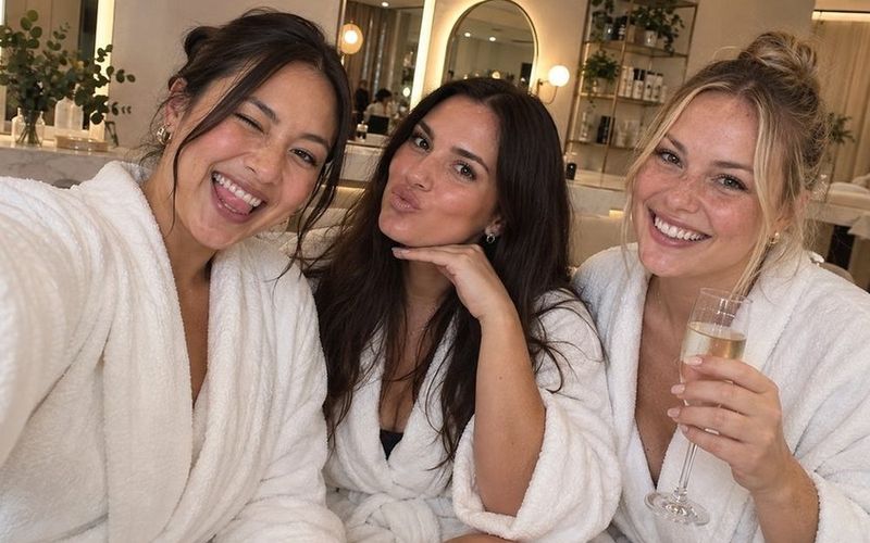 Three friends in spa robes pulling faces for a selfie with bubbly on a Gold Coast girls weekend