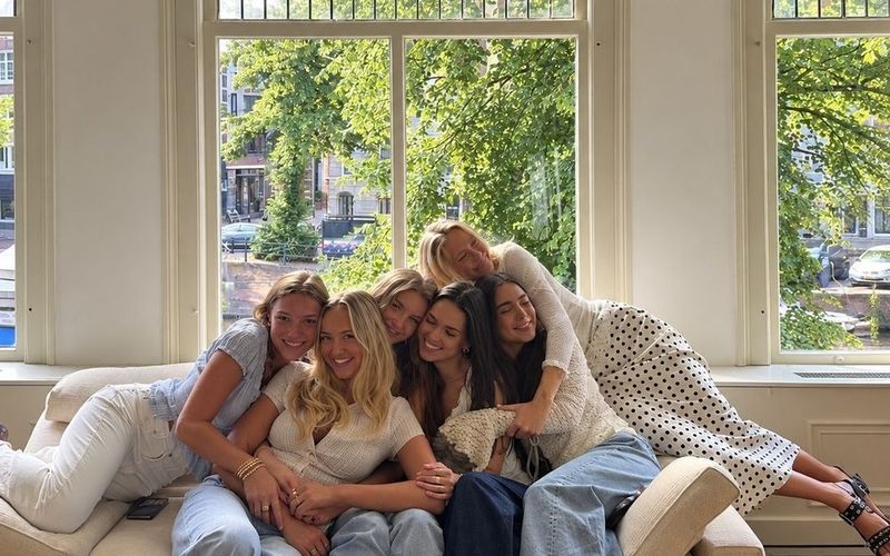 The girls cuddled up and laughing together on the couch on a Gold Coast girls weekend