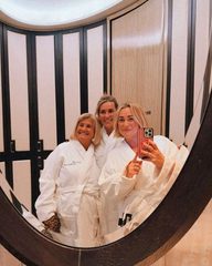 Three friends in day spa robes taking a mirror selfie