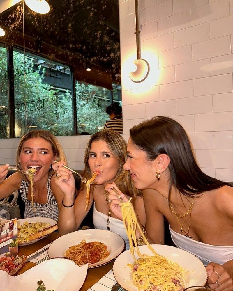 Three friends twirling spaghetti at an Italian restaurant