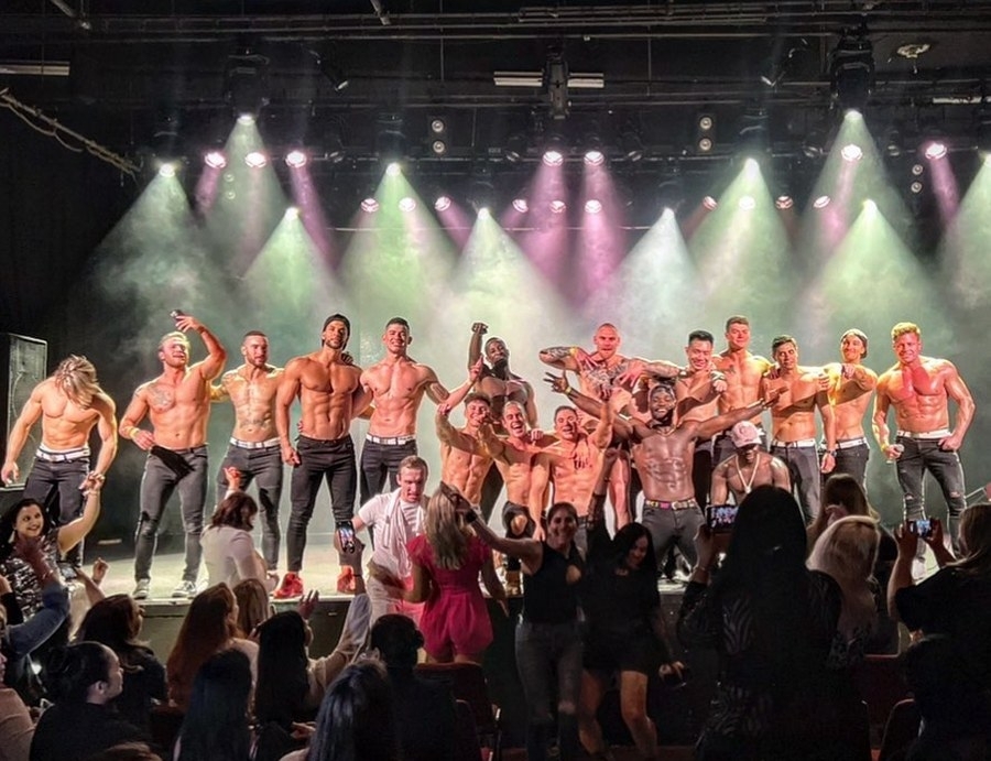 The stage lights up as the male revue performs to a packed crowd
