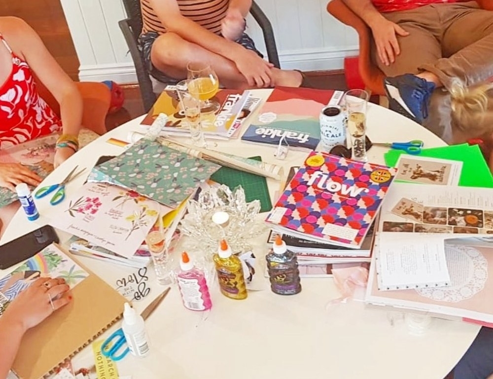 Magazines, scissors and glue spread across the table during a vision board workshop