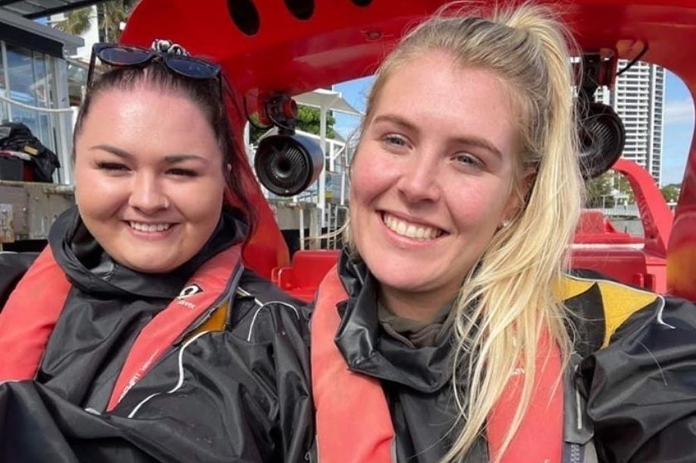 Two friends in life jackets grinning on a Sydney Harbour jet boat
