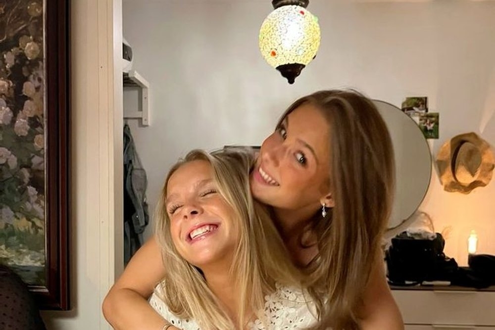 Two friends hugging and grinning in the apartment