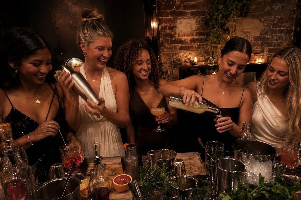 Friends shaking and pouring their own cocktails at a cocktail class