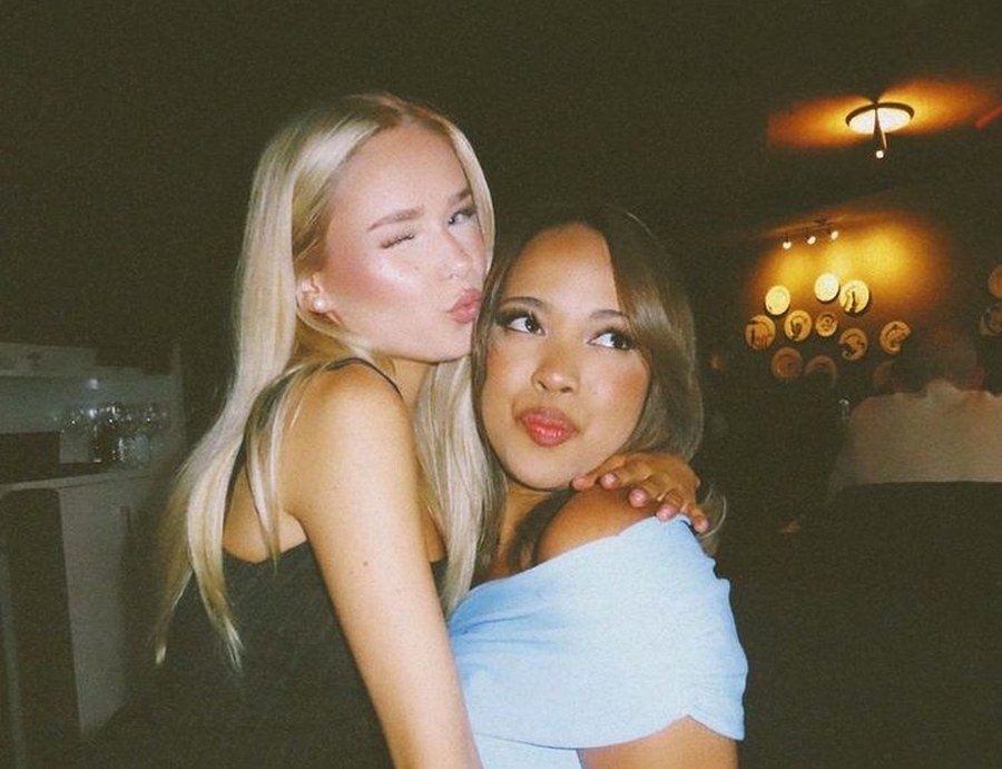 Two friends winking and pouting in a flash photo at a bar