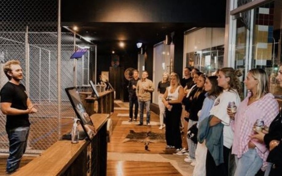 The girls lined up at the axe throwing lanes for their coach’s briefing