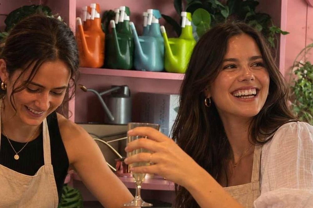 Two friends laughing as they plant succulents at a terrarium workshop