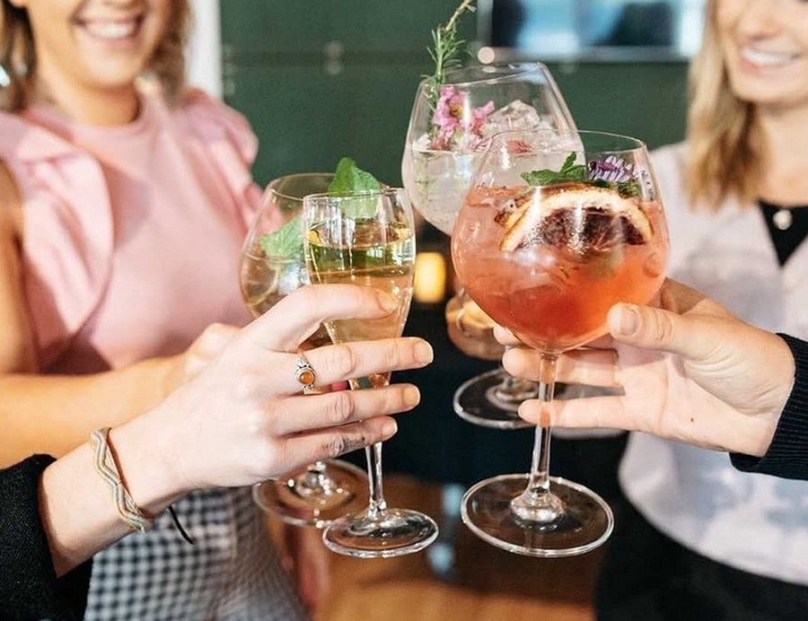 Friends clinking glasses together over an afternoon catch up