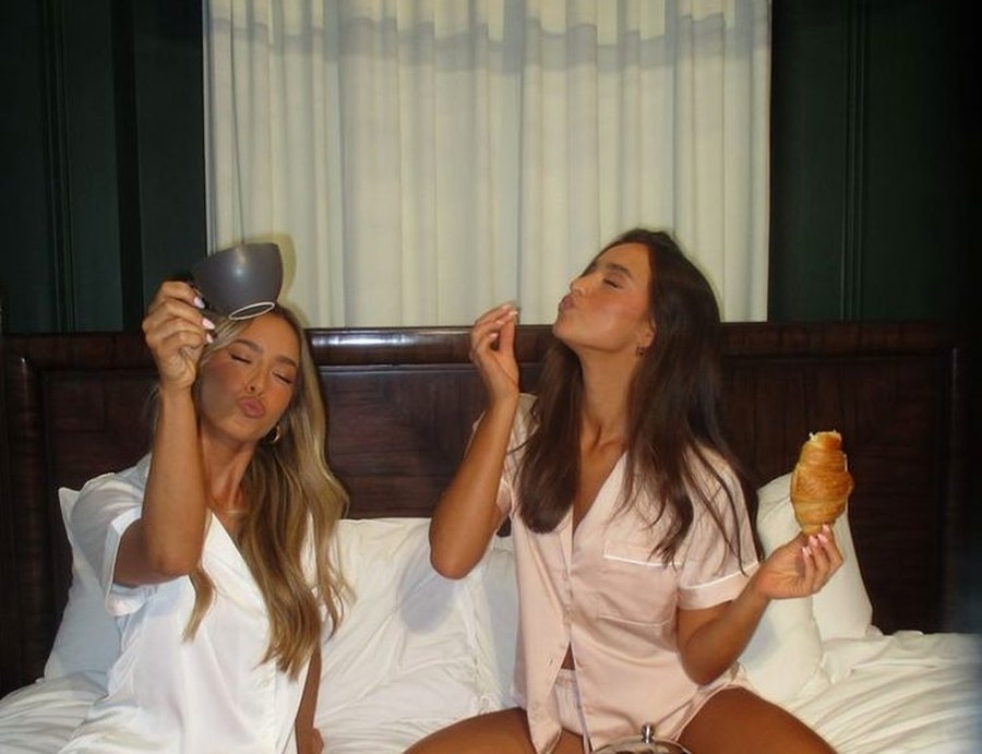Two friends in pyjamas goofing around in bed after a big day