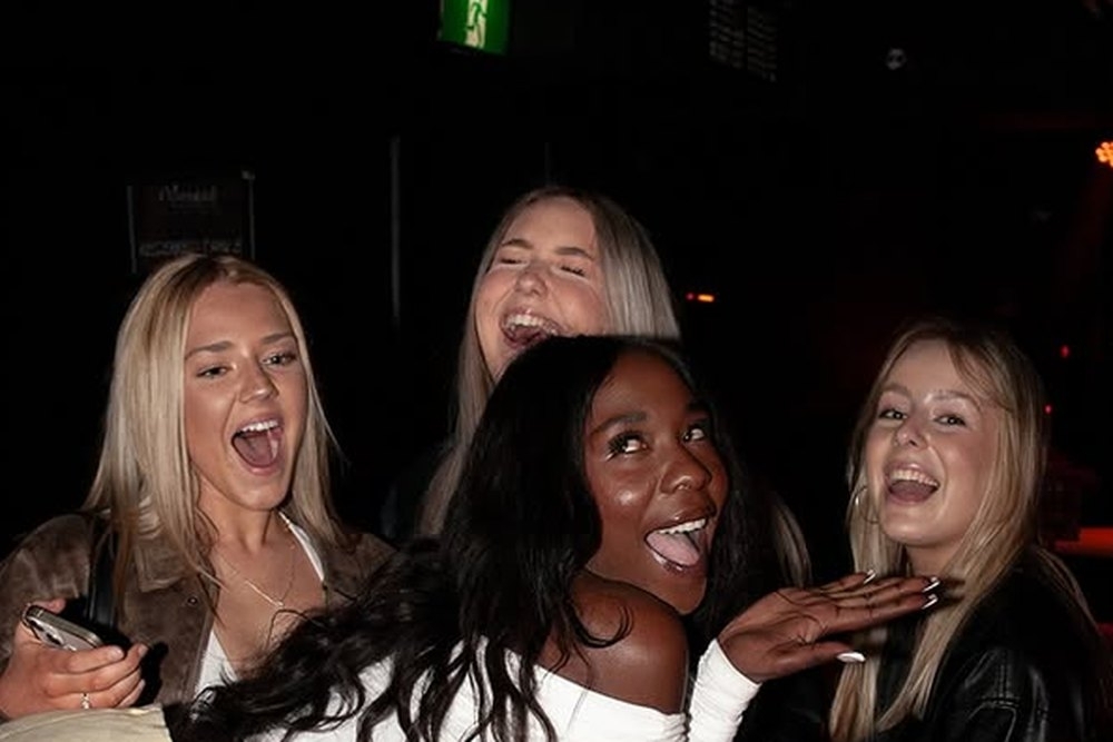 Friends shrieking with laughter around a table on a late night out