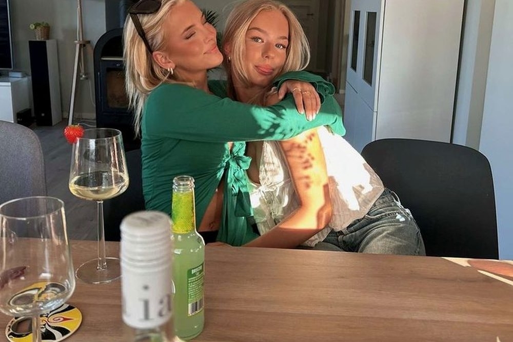 Two friends hugging at the dining table back at the apartment