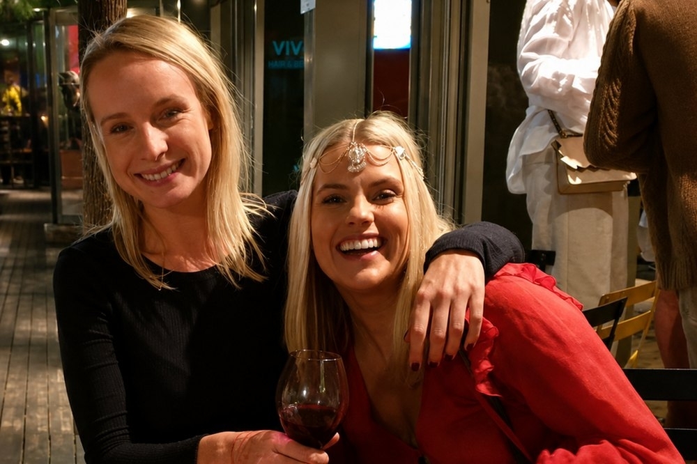 Two friends laughing together over a grazing spread