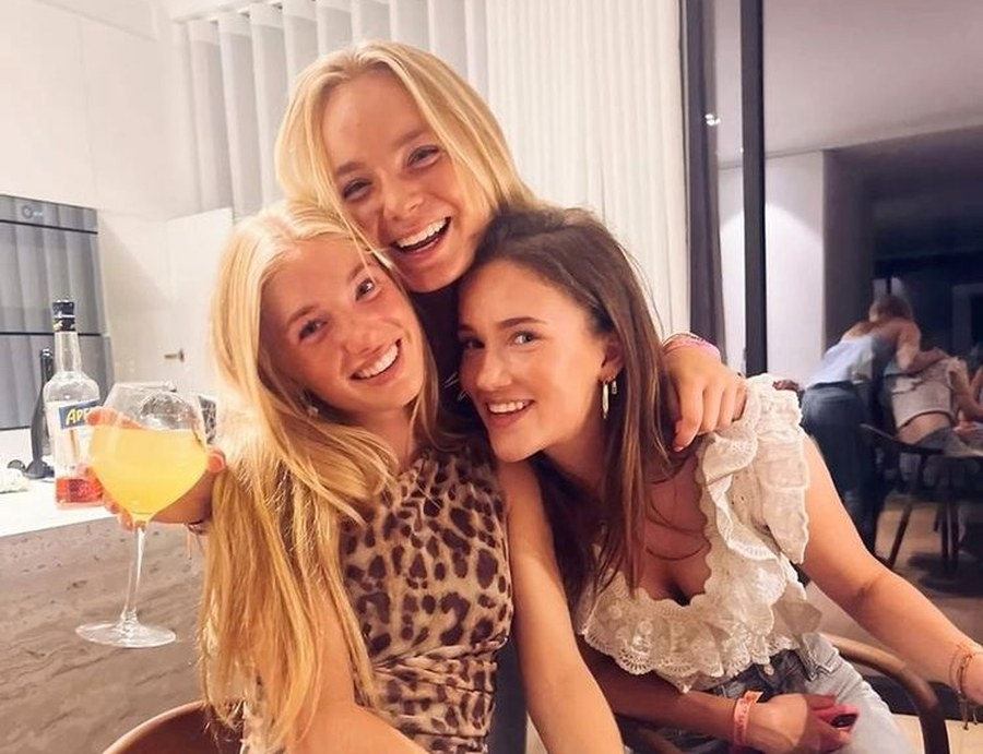 Three friends hugging and laughing back at the apartment