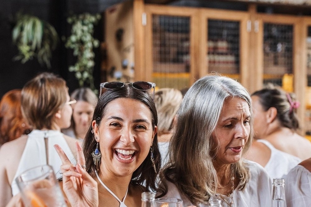Friends laughing and toasting around a tasting table at the distillery