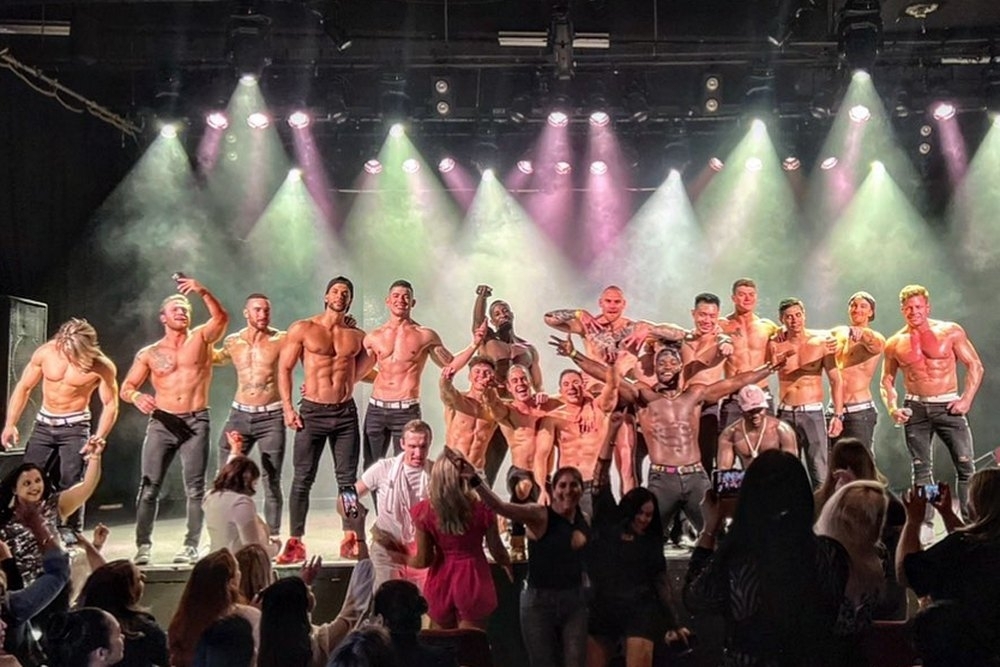 The girls cheering from the crowd as the male revue cast takes the stage